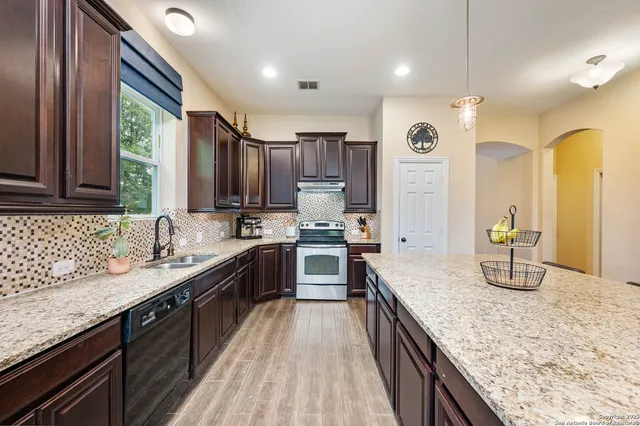 a large kitchen with a sink and cabinets