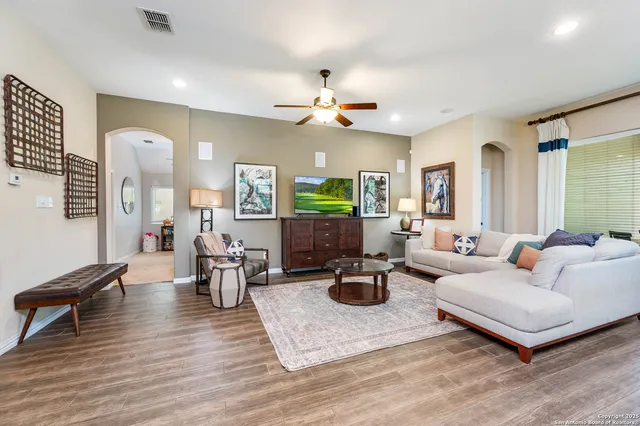 a living room with furniture kitchen view and a chandelier