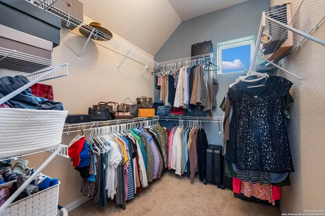 a view of walk in closet with clothes