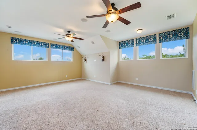 an empty room with windows and fan