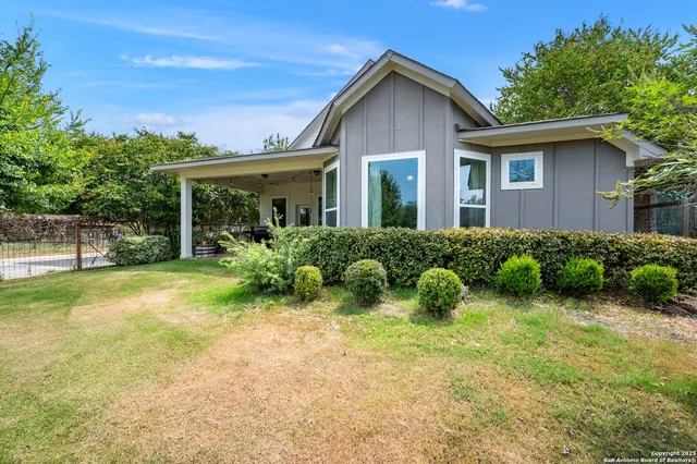 a view of a house with backyard sitting area and garden