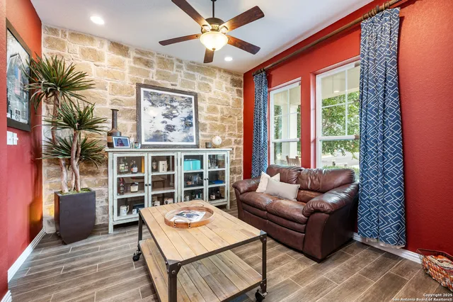a living room with furniture a rug and a floor to ceiling window