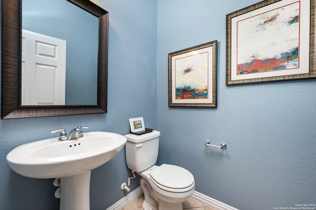 a bathroom with a toilet a sink and mirror