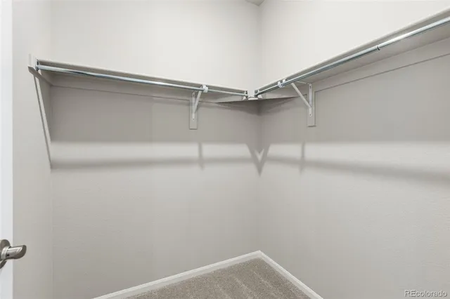 a view of walk in closet with empty racks