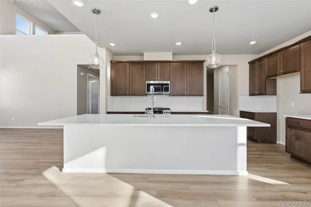 a view of kitchen with stainless steel appliances kitchen island sink and refrigerator