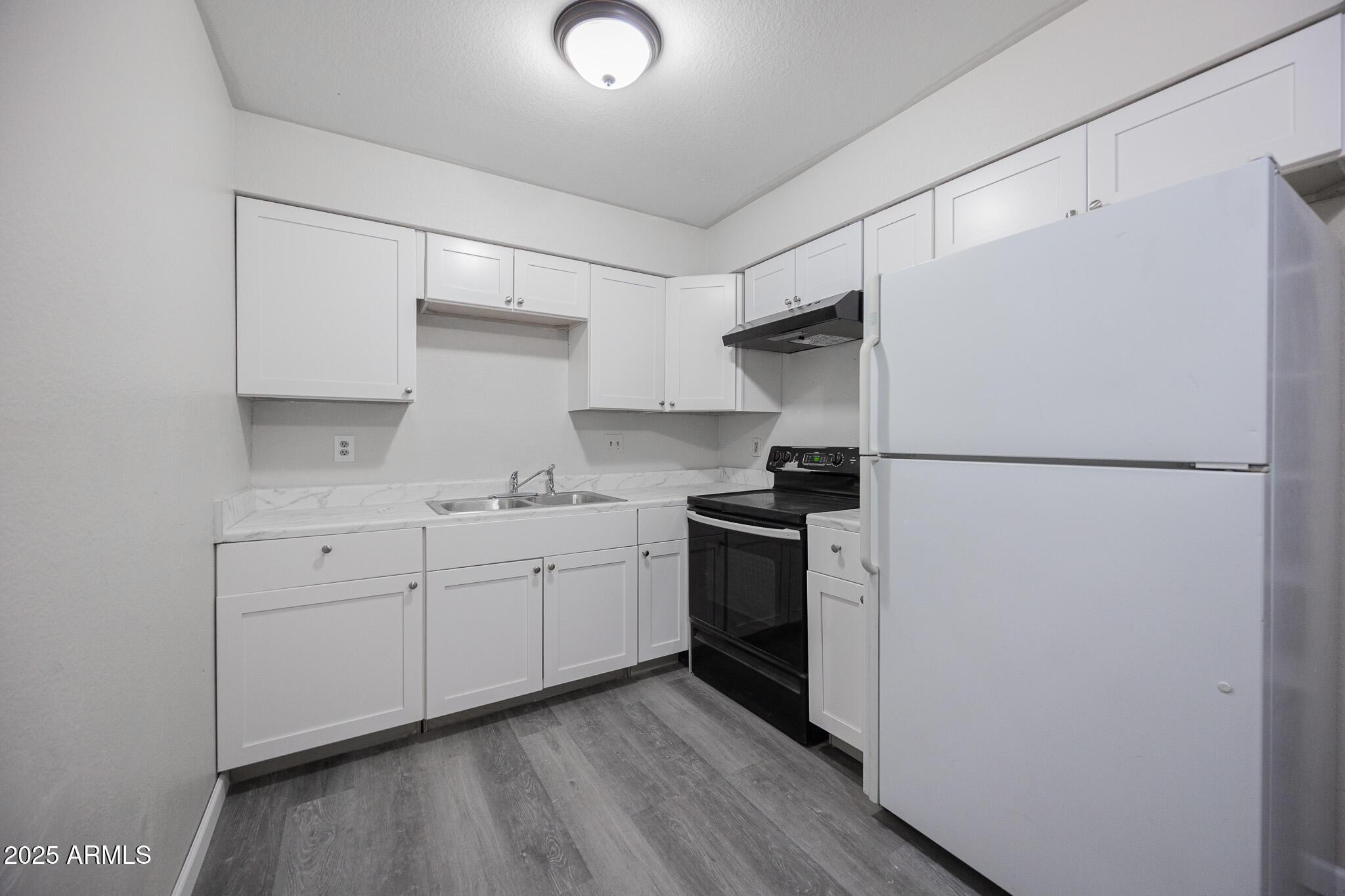 2340 East Broadway Road, Unit A Mesa, AZ 85204 - Photo 7 of 14 a kitchen with stainless steel appliances a refrigerator sink and cabinets
