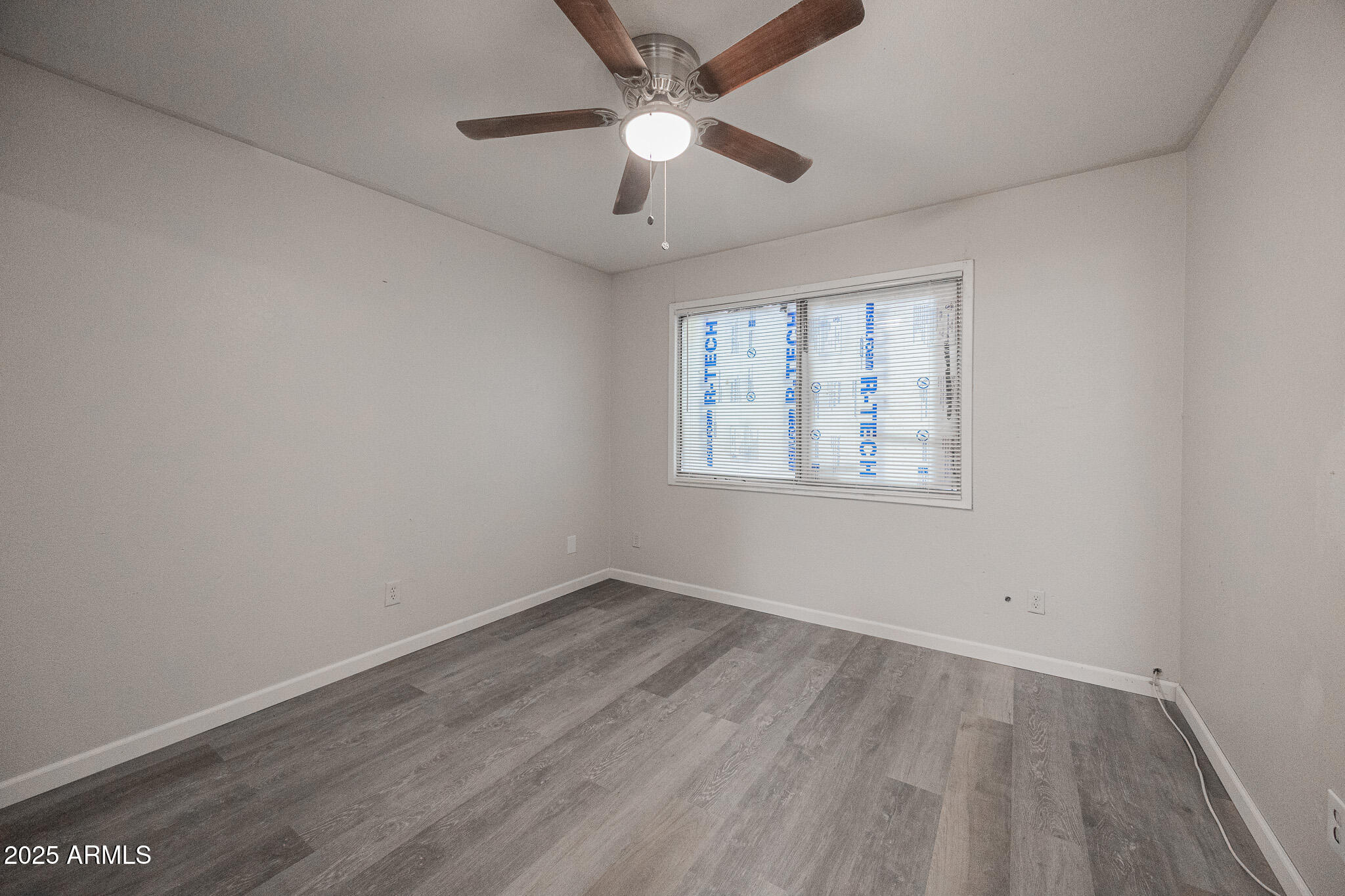 2340 East Broadway Road, Unit A Mesa, AZ 85204 - Photo 8 of 14 an empty room with wooden floor ceiling fan and windows