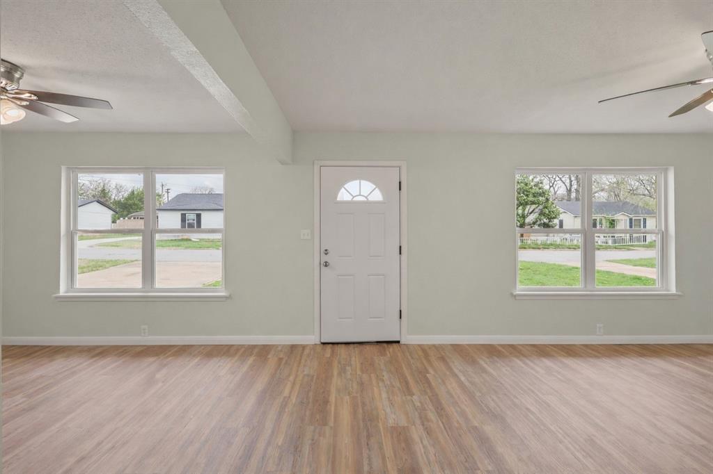 732 Bullock Street Denison, TX 75020 - Photo 8 of 29 an empty room with wooden floor and windows