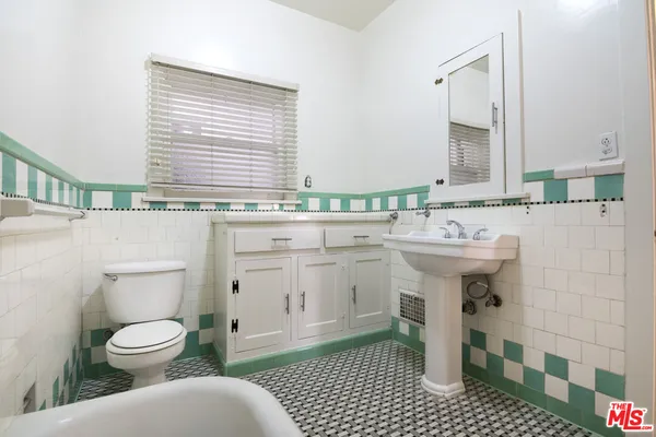 a bathroom with a sink a toilet a mirror and shower