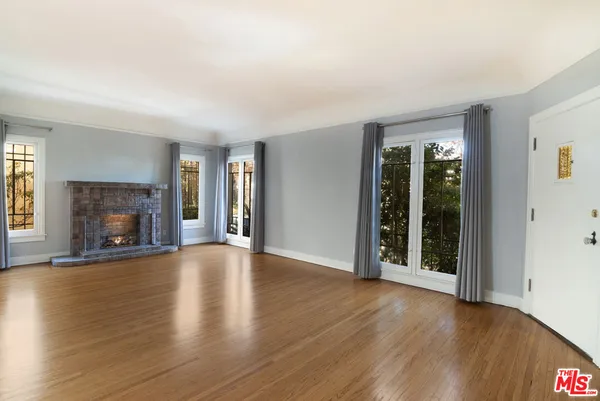 an empty room with wooden floor and fireplace