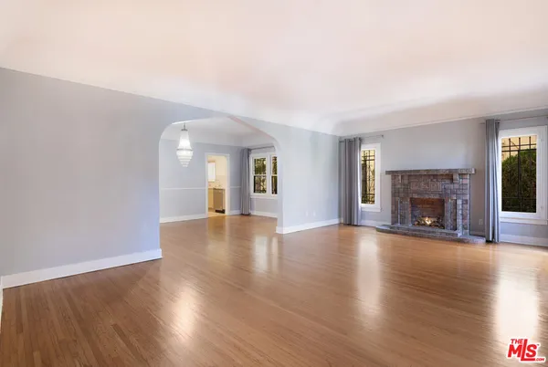 a view of a livingroom with wooden floor and a fireplace