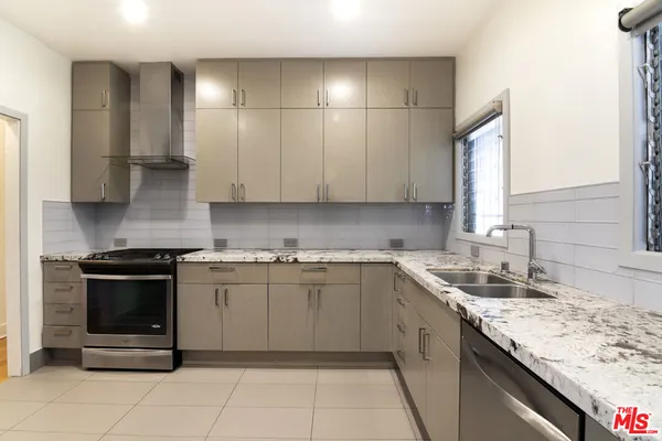 a kitchen with stainless steel appliances granite countertop a sink stove and cabinets