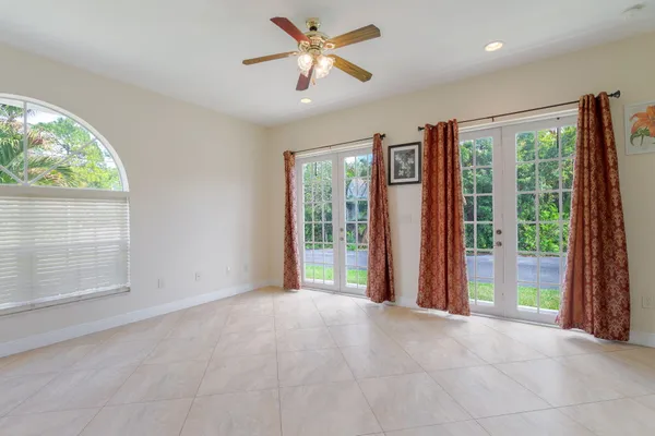 a view of an empty room with a window and a kitchen
