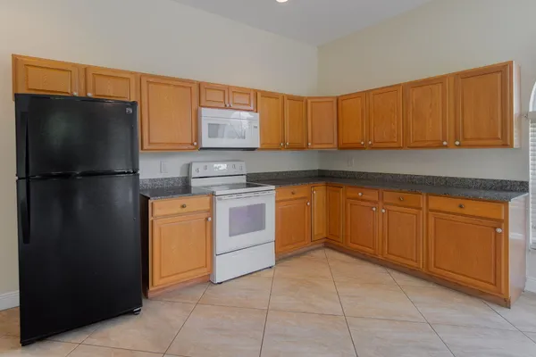 a kitchen with a refrigerator sink and cabinets
