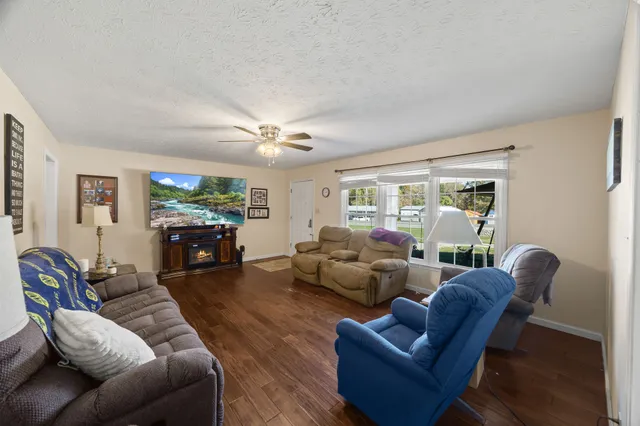 a living room with furniture a large window and a flat screen tv