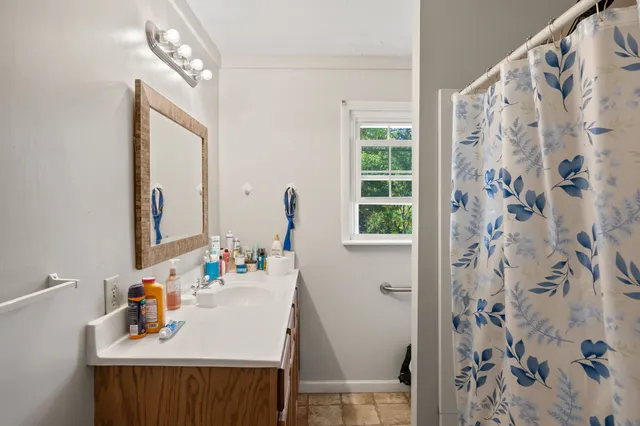 a bathroom with a sink a mirror and a window