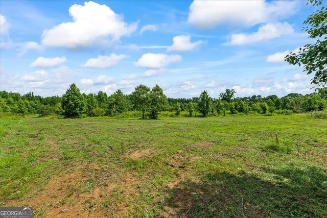 a view of a green field with wooden fence
