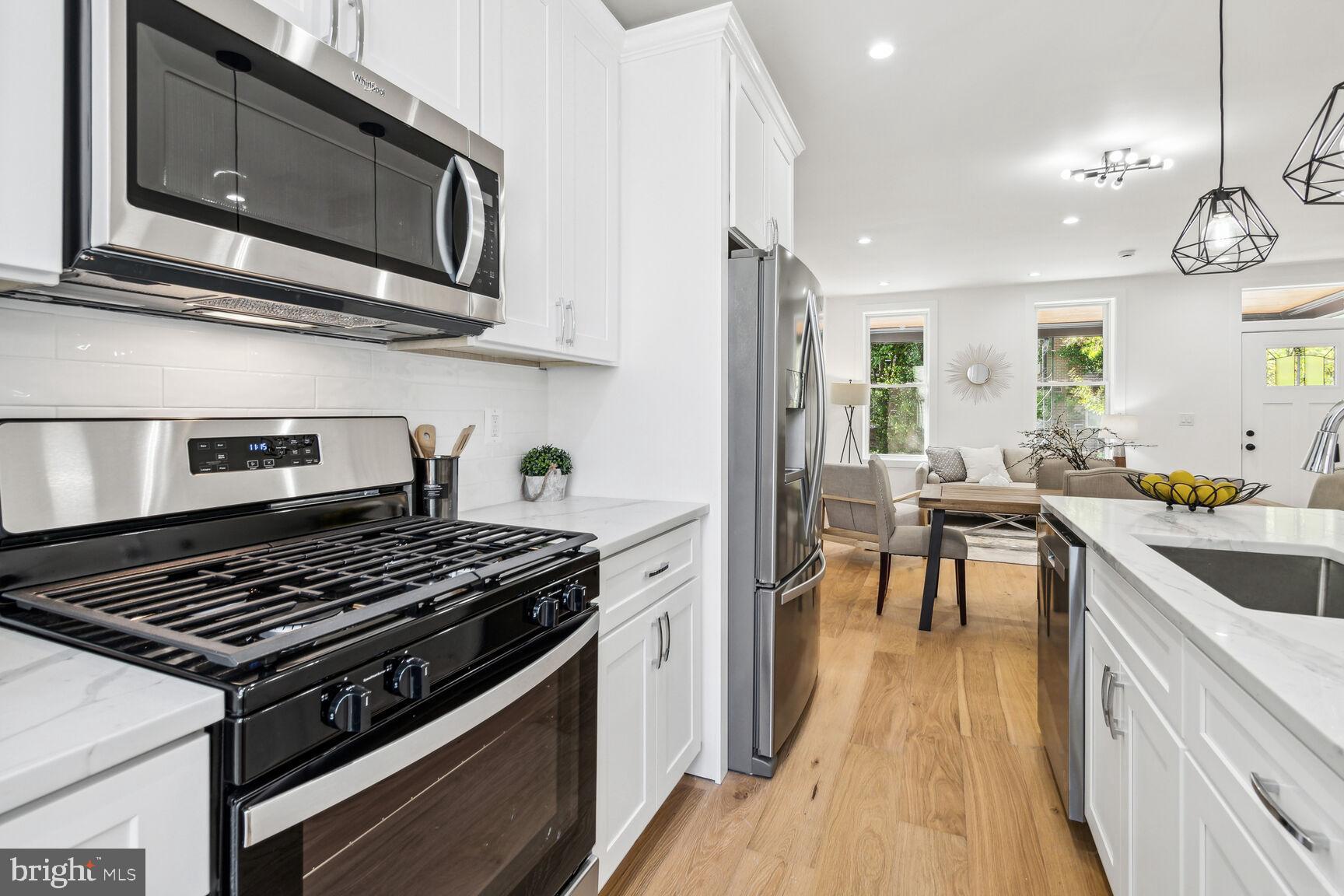 1410 A Street Northeast Washington, DC 20002 - Photo 11 of 35 a kitchen with stainless steel appliances granite countertop a stove a sink dishwasher and cabinets with wooden floor