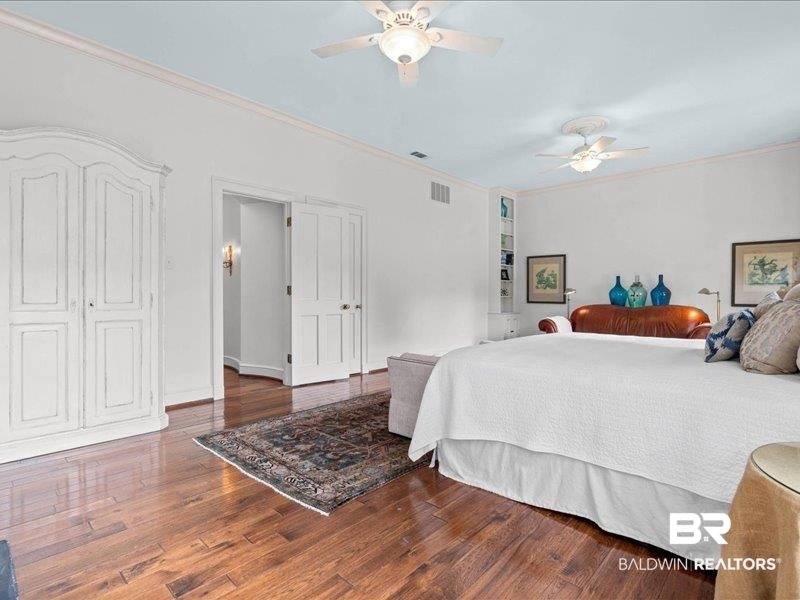 109 Eaton Square Mobile, AL 36608 - Photo 13 of 26 Spacious room featuring wood-finish flooring, white walls with crown molding, and two ceiling fans