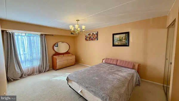 a bedroom with a bed window and a chandelier
