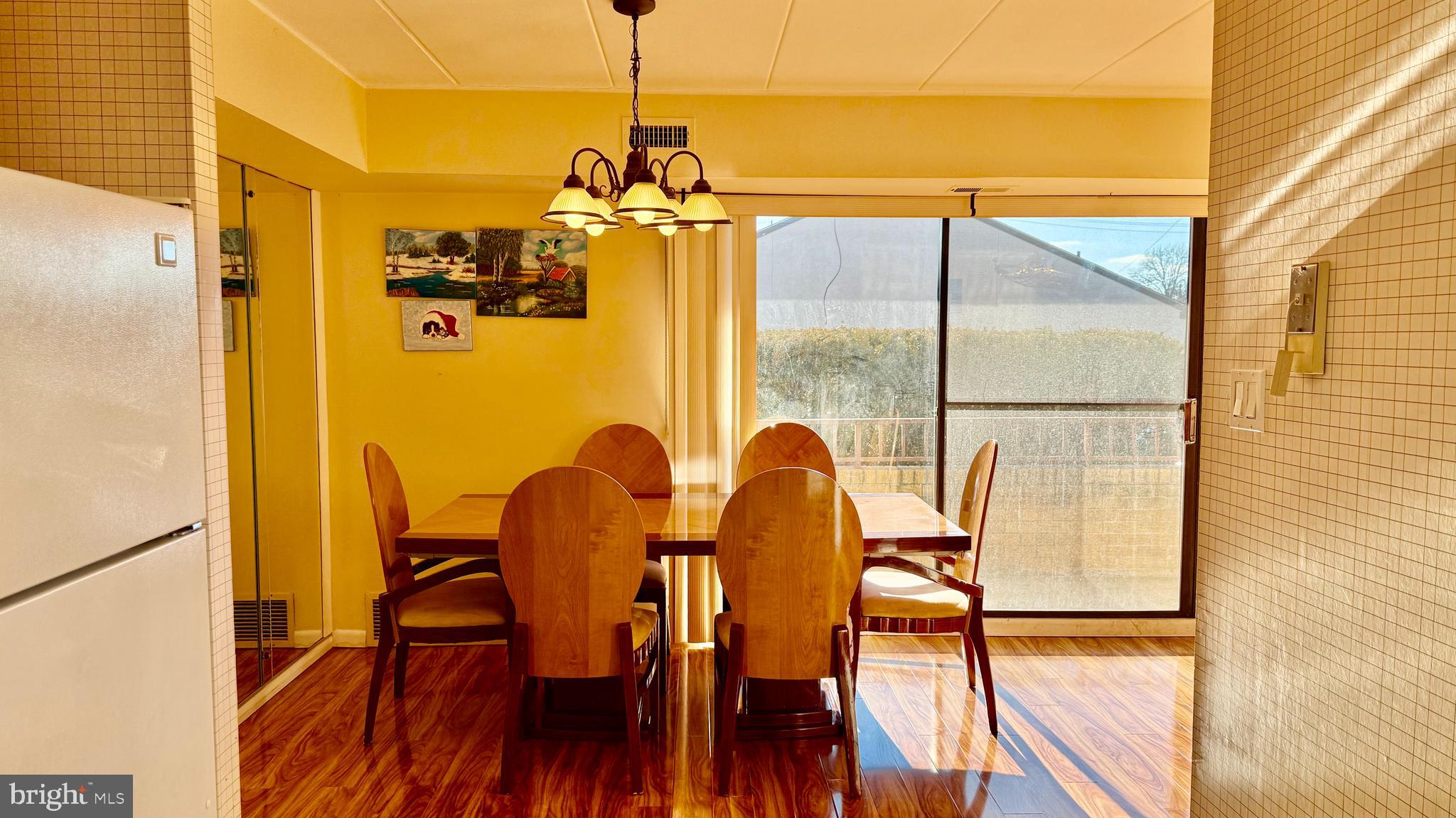 8910 Krewstown Road, Unit 118 Philadelphia, PA 19115 - Photo 13 of 15 a view of a dining room with furniture a chandelier and wooden floor