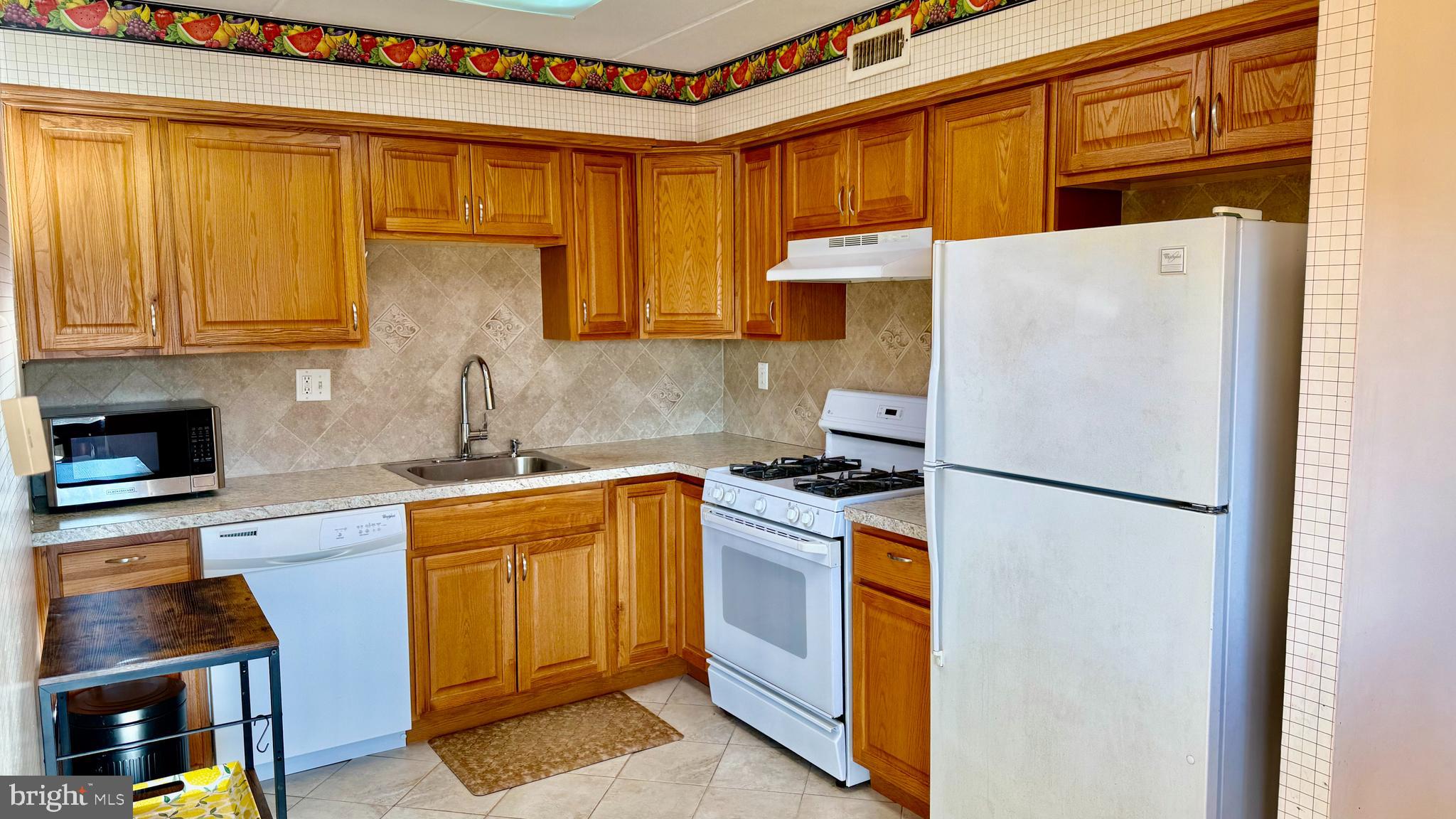 8910 Krewstown Road, Unit 118 Philadelphia, PA 19115 - Photo 15 of 15 a kitchen with stainless steel appliances granite countertop a refrigerator a stove a sink dishwasher and a microwave oven