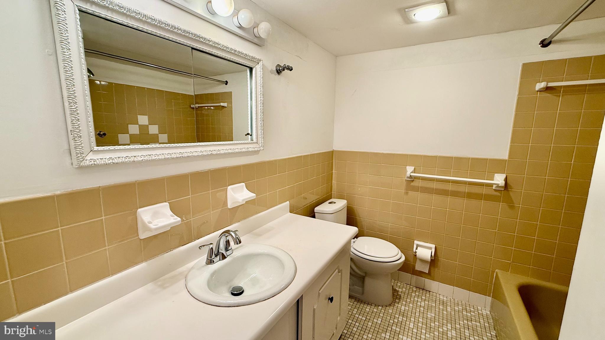 8910 Krewstown Road, Unit 118 Philadelphia, PA 19115 - Photo 7 of 15 a bathroom with a sink a toilet and mirror
