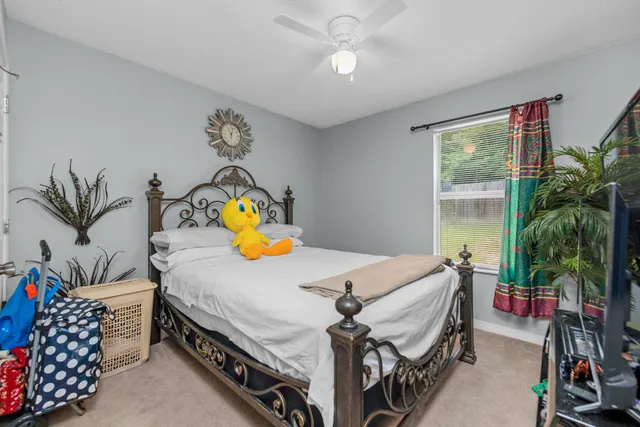 a bedroom with a bed a couch and potted plant