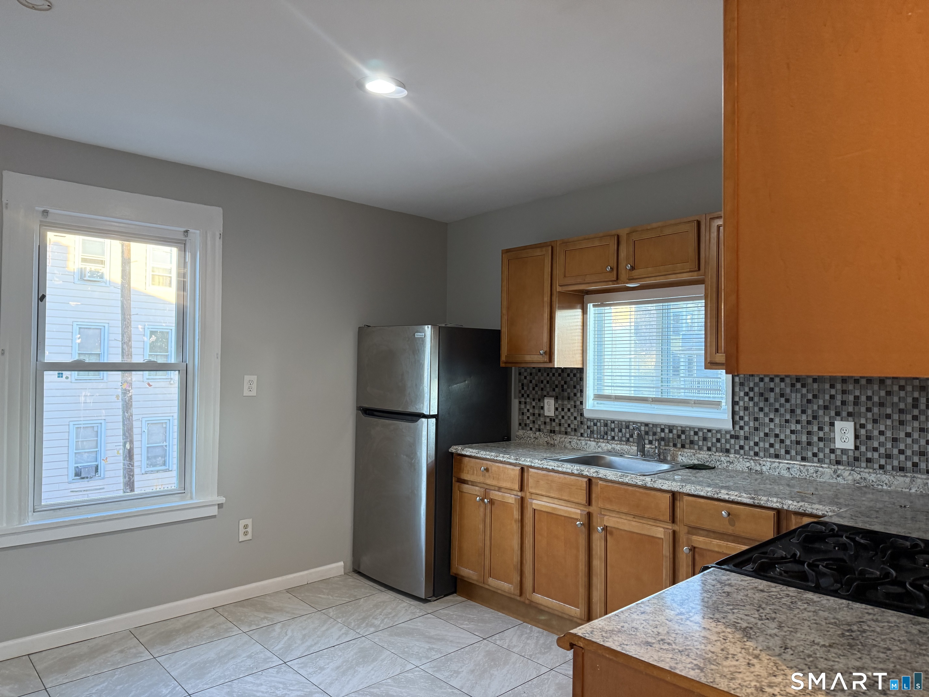 276 Orchard Street Bridgeport, CT 06608 - Photo 2 of 14 a kitchen with stainless steel appliances granite countertop a refrigerator and a sink