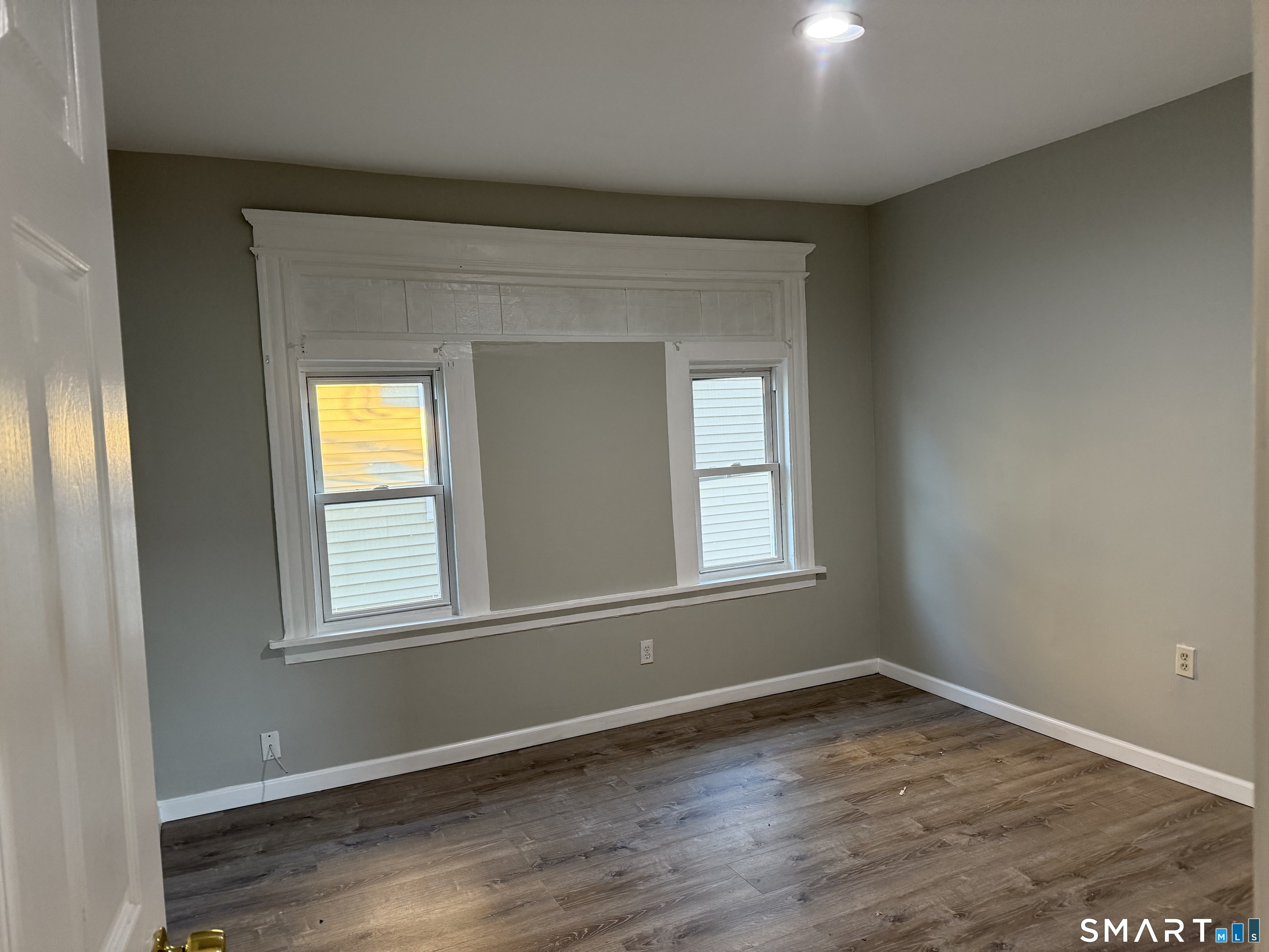 276 Orchard Street Bridgeport, CT 06608 - Photo 4 of 14 a view of an empty room with wooden floor and a window