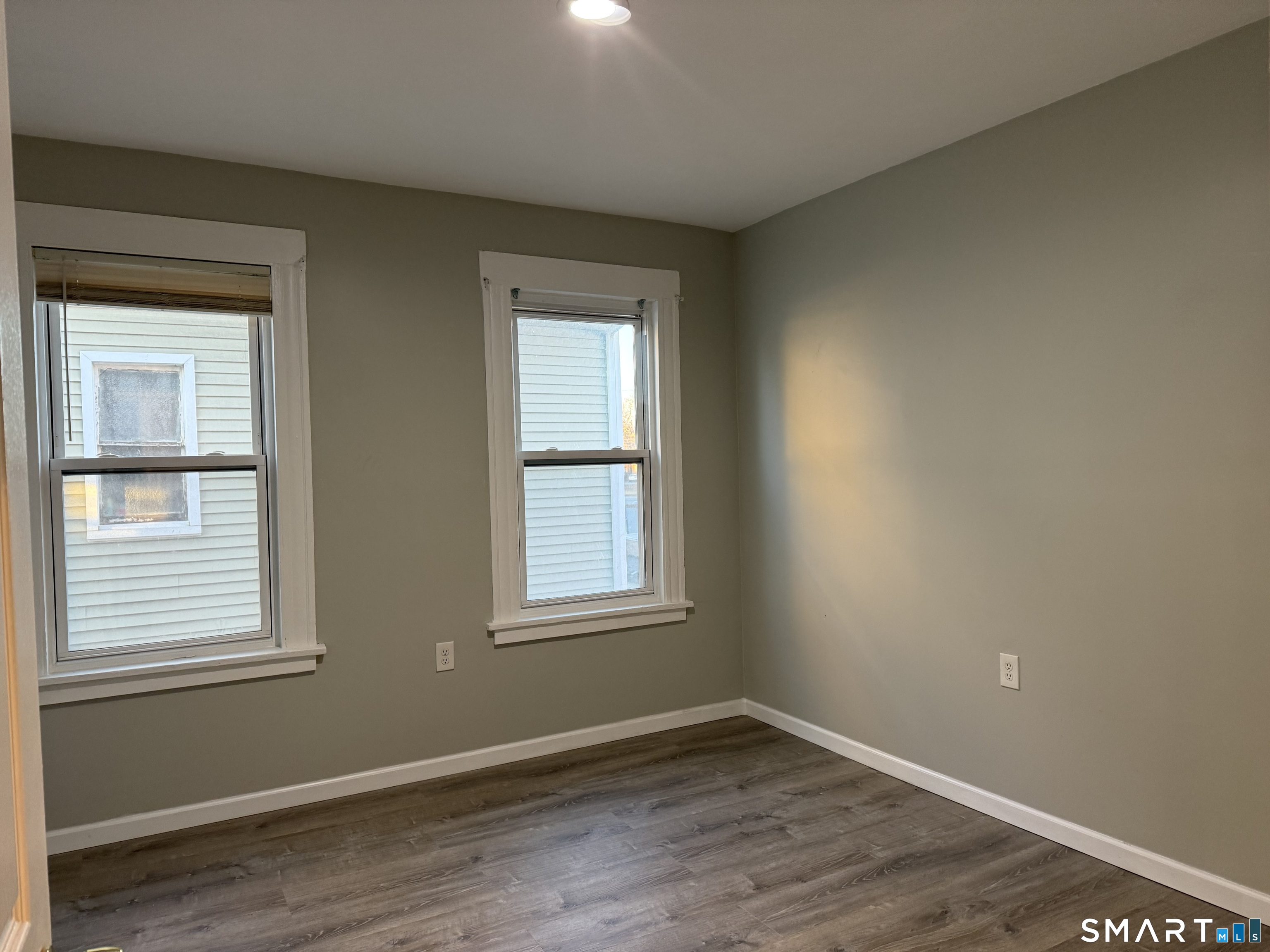 276 Orchard Street Bridgeport, CT 06608 - Photo 6 of 14 an empty room with wooden floor and windows