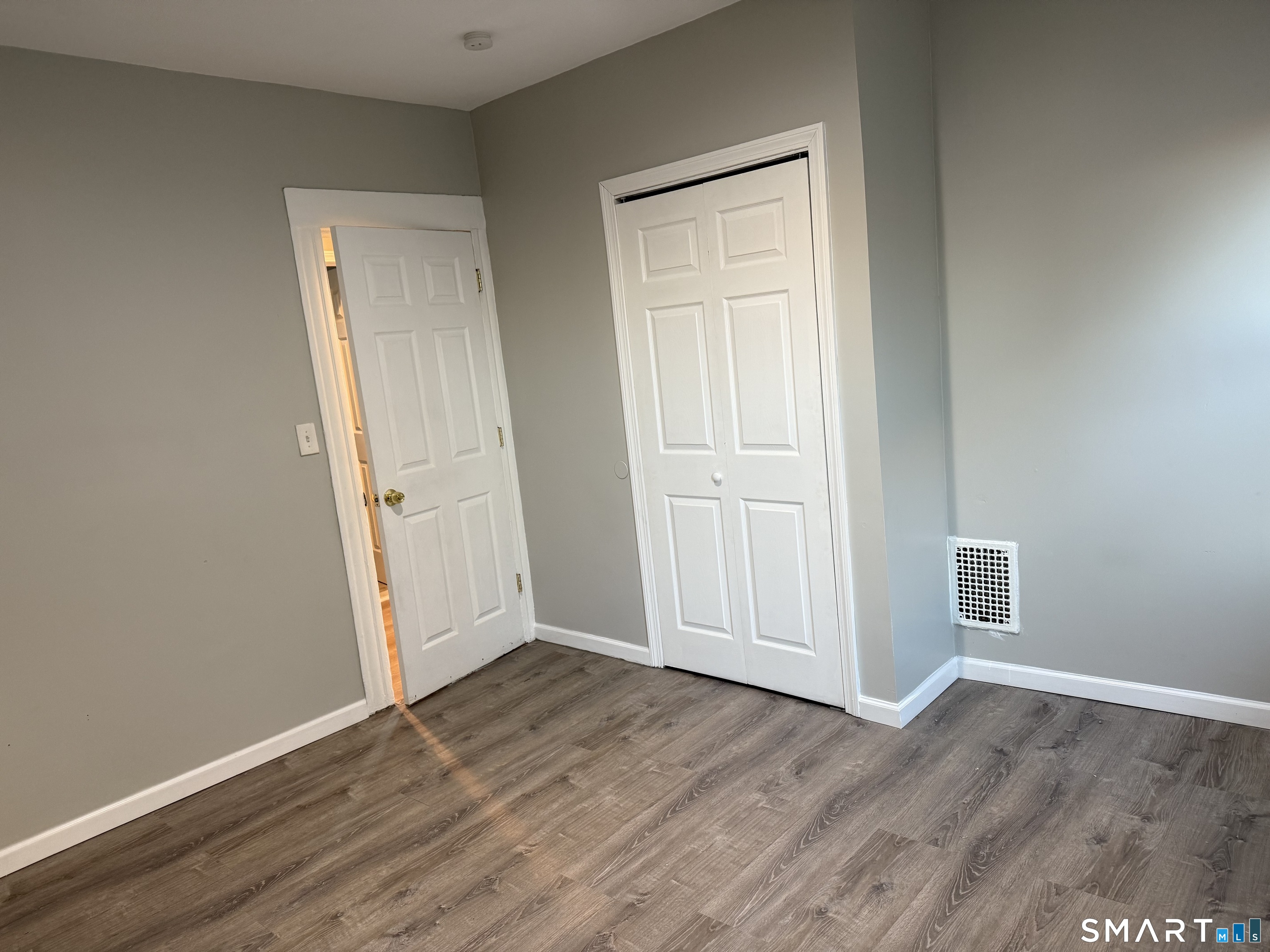 276 Orchard Street Bridgeport, CT 06608 - Photo 7 of 14 an empty room with wooden floor