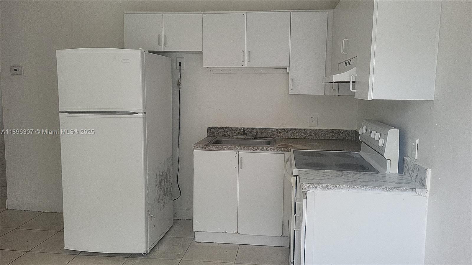 848 Southwest 5th Street, Unit 103 Homestead, FL 33030 - Photo 1 of 10 a kitchen with a refrigerator sink and cabinets
