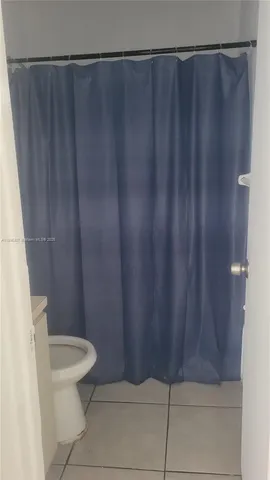 a bathroom with a shower curtain and toilet