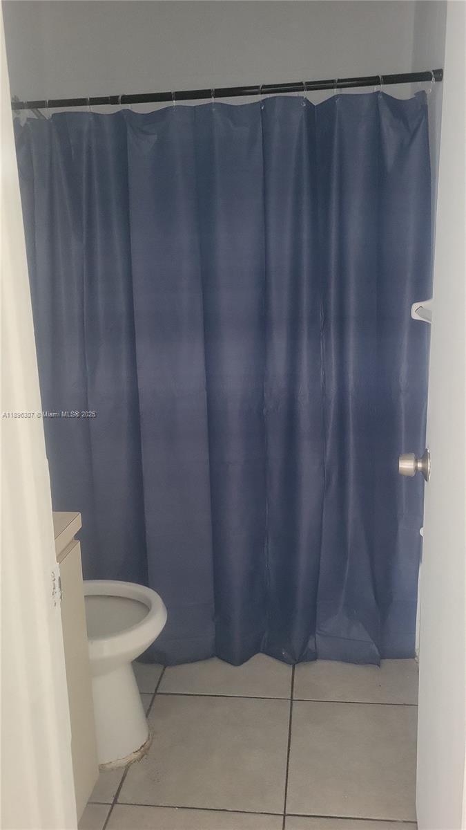 848 Southwest 5th Street, Unit 103 Homestead, FL 33030 - Photo 4 of 10 a bathroom with a shower curtain and toilet