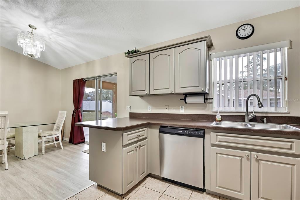 103 Daisy Lane Inverness, FL 34452 - Photo 13 of 40 a kitchen with stainless steel appliances granite countertop a sink cabinets and wooden floor