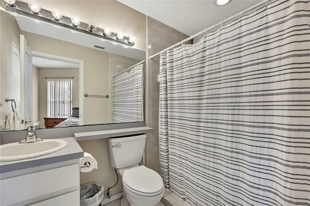 a bedroom with a bed and a lamp on the dresser