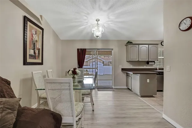 a kitchen with stainless steel appliances granite countertop a stove top oven a chimney cabinets and wooden floor