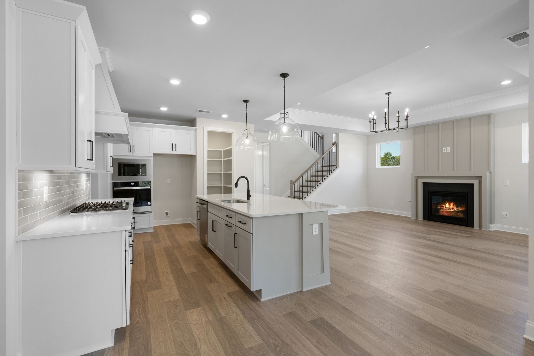 7318 Winners Road Murfreesboro, TN 37129 - Photo 18 of 44 a large white kitchen with stainless steel appliances granite countertop a stove oven a sink dishwasher and a fireplace with wooden floor