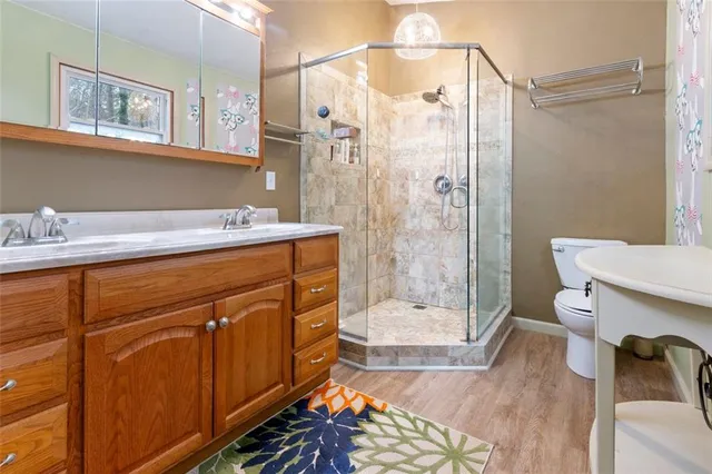 a bathroom with a sink a toilet and shower