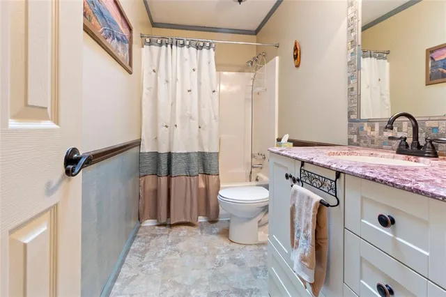 a bathroom with a granite countertop sink toilet and shower