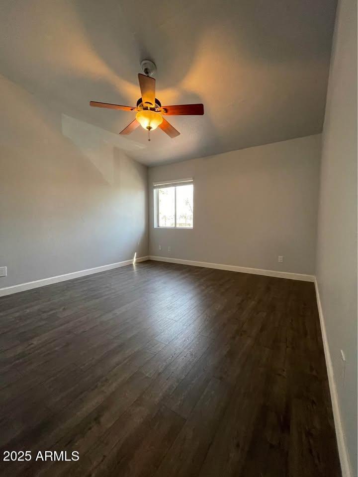 1455 North Alma School Road, Unit 11 Mesa, AZ 85201 - Photo 13 of 22 an empty room with wooden floor fan and windows