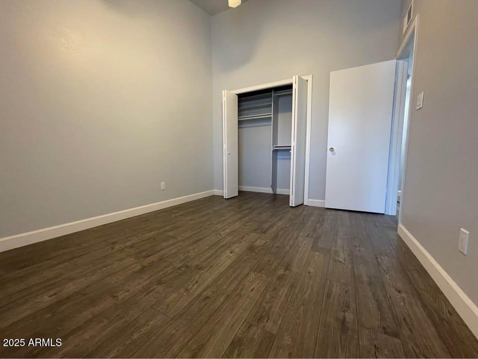 1455 North Alma School Road, Unit 11 Mesa, AZ 85201 - Photo 15 of 22 a view of an empty room with wooden floor and closet
