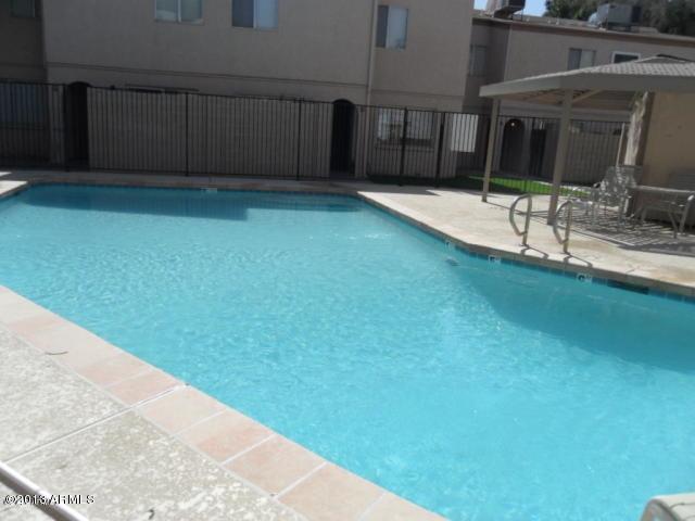 1455 North Alma School Road, Unit 11 Mesa, AZ 85201 - Photo 20 of 22 a view of a backyard with table and chairs and wooden fence