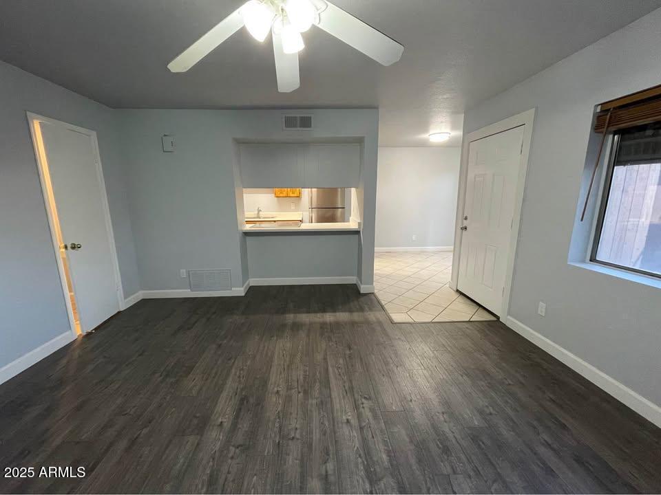1455 North Alma School Road, Unit 11 Mesa, AZ 85201 - Photo 4 of 22 an empty room with wooden floor and windows