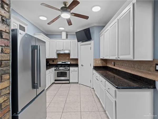 a kitchen with stainless steel appliances granite countertop a stove a sink and a refrigerator