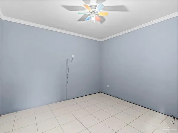 an empty room with fan and entryway