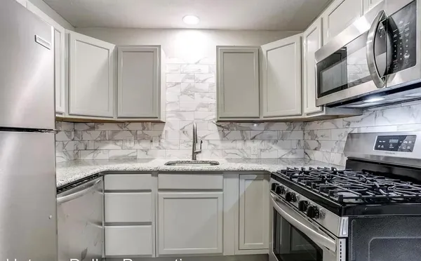 a kitchen with stainless steel appliances granite countertop a sink stove top oven and microwave