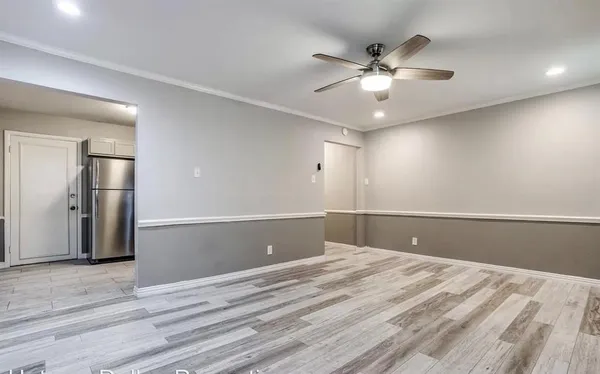 a view of a livingroom with a ceiling fan and wooden floor