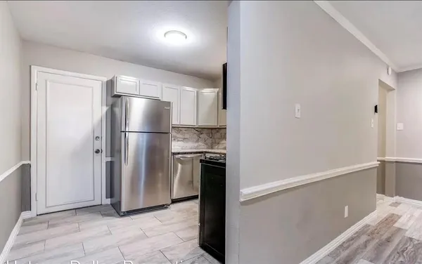 a kitchen with a refrigerator and a stove top oven